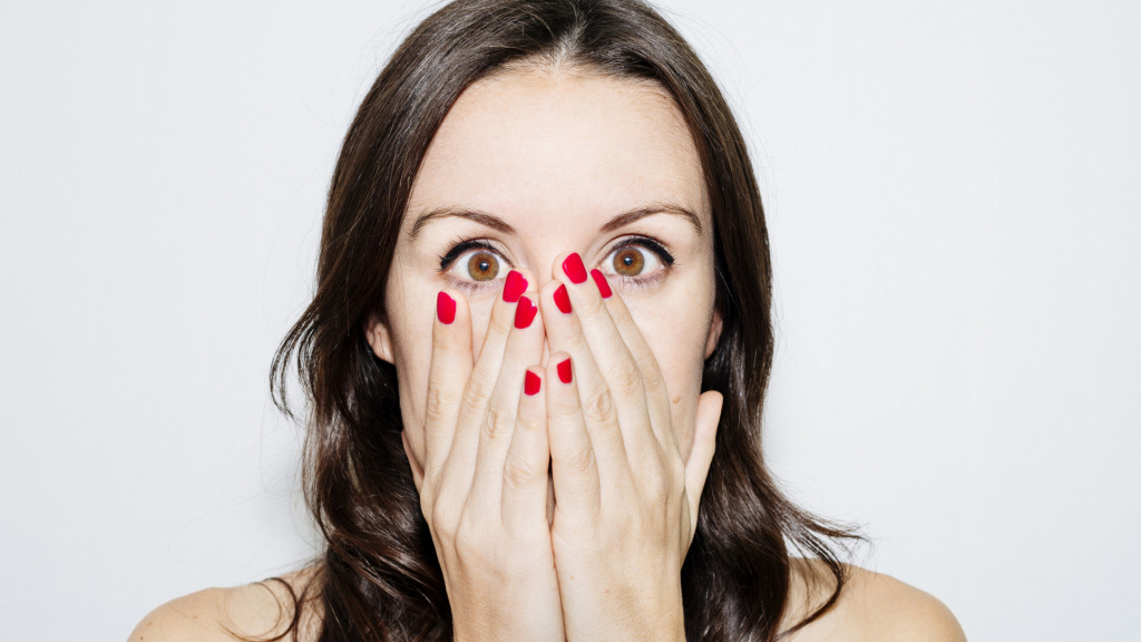 Beautiful woman with hands on face and red nails