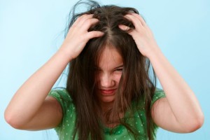 Girl scratching head, lice
