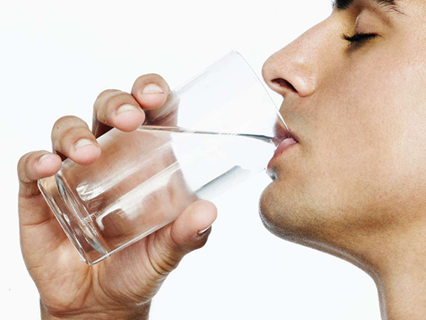 man drinking water from the glass